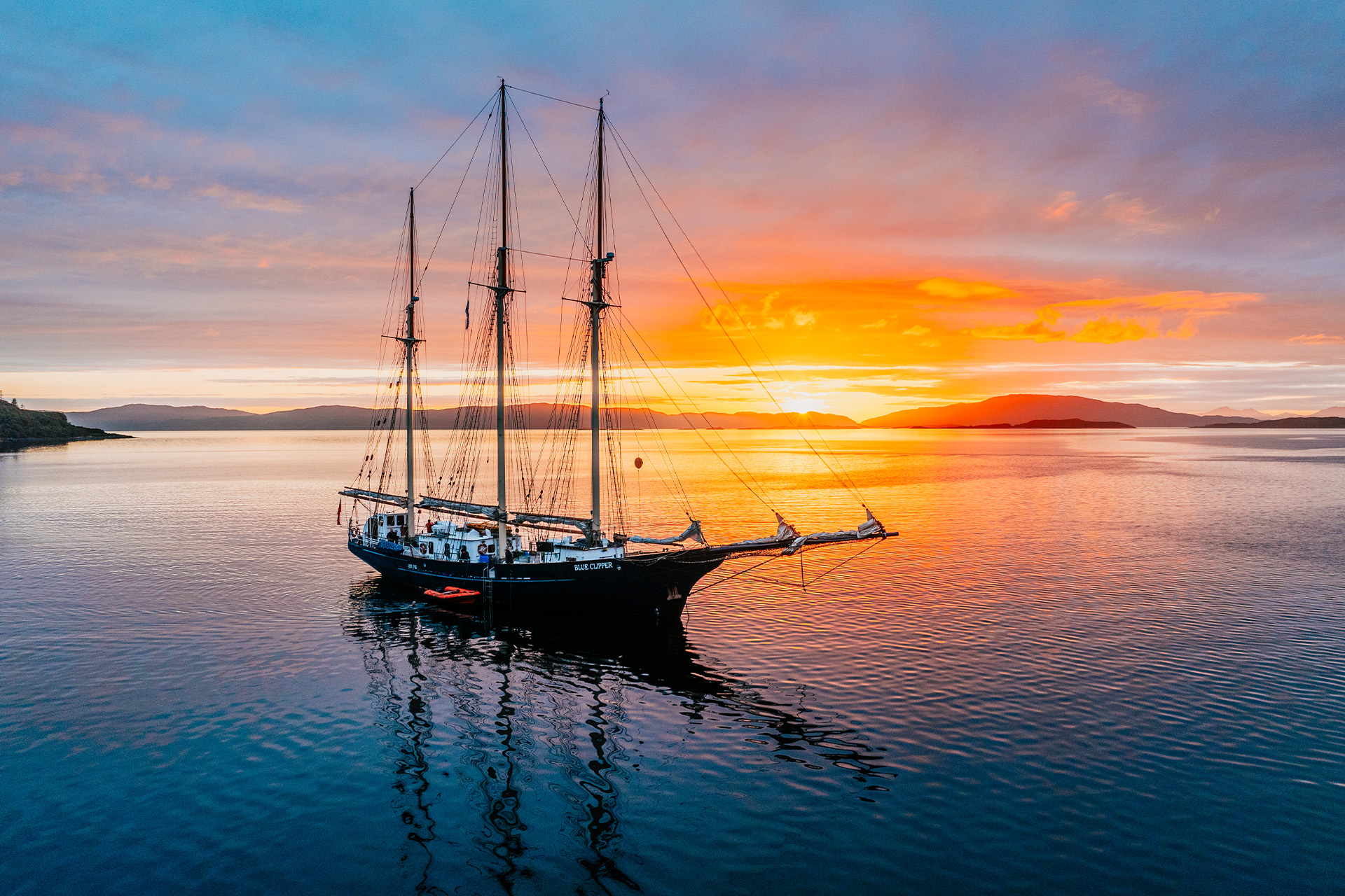 Blue Clipper tall ship anchored at sunset